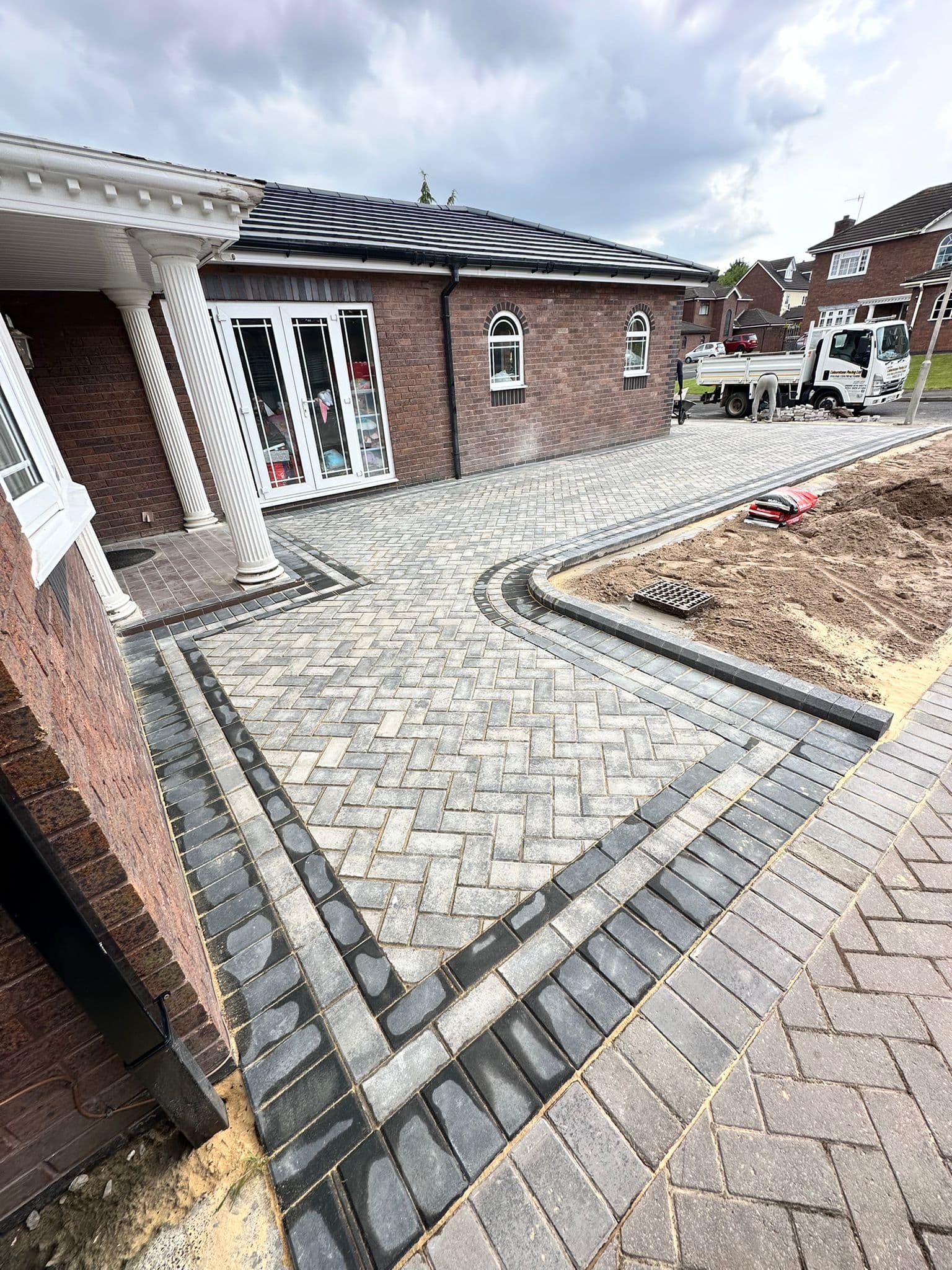 Block paving driveway under construction, showing the edging course being set