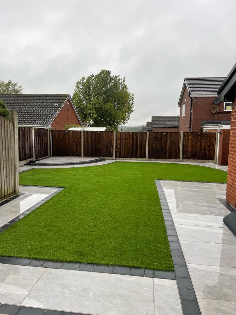 Artificial lawn in a small enclosed garden, finished up to new paving