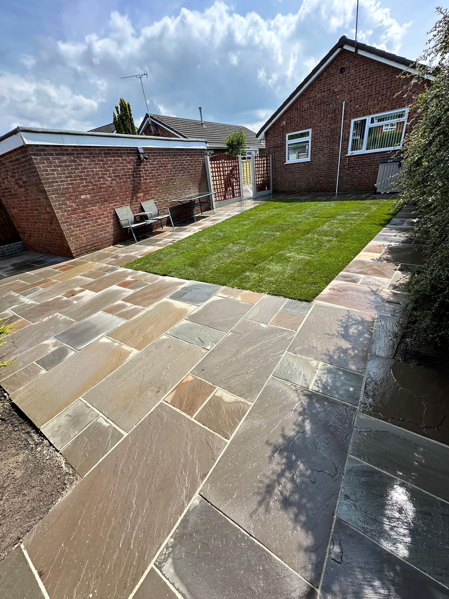 Indian sandstone patio with natural colour variation, finished up to the lawn